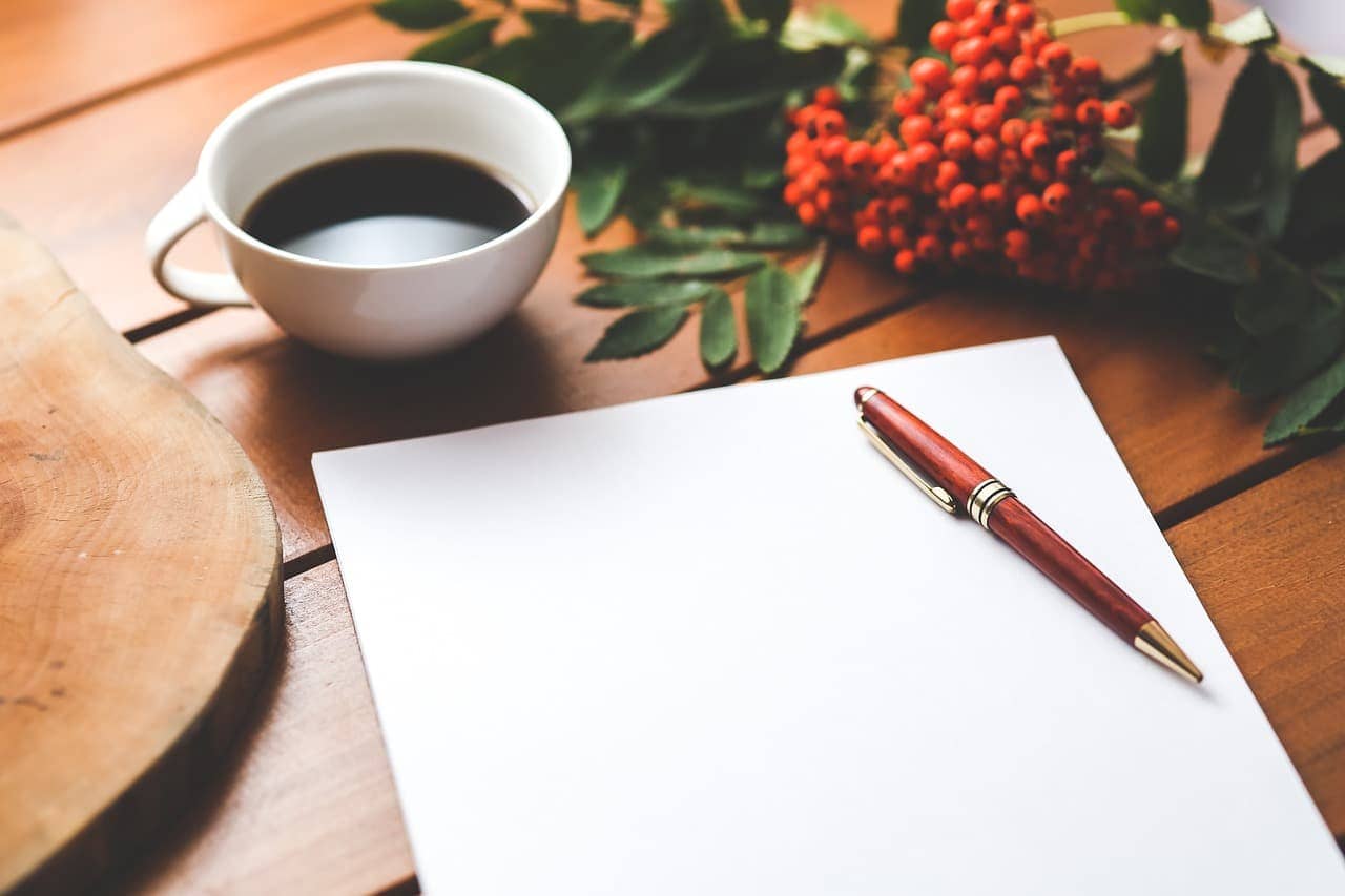 An open journal with a list of gratitude entries and a pen beside it